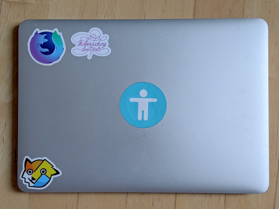 Laptop with Firefox and DevTools stickers.